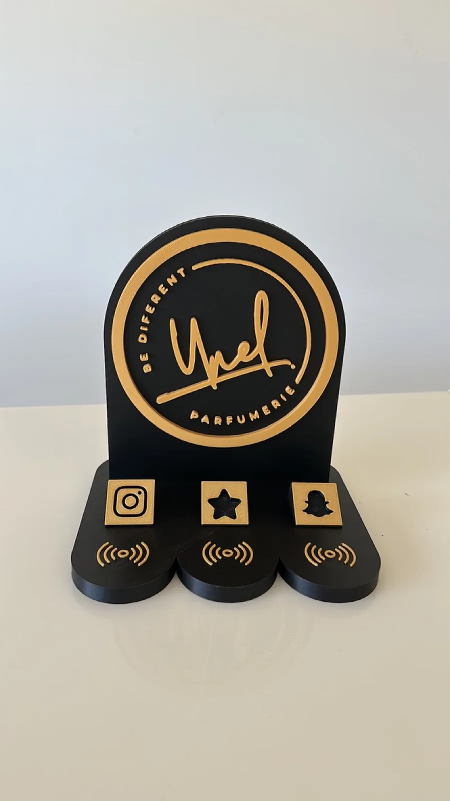 Stand NFC Filon Médoc noir et or de la parfumerie Smell Like Ynel à Lesparre-Médoc, avec ses 3 logos réseaux Instagram, avis Google et Snapchat